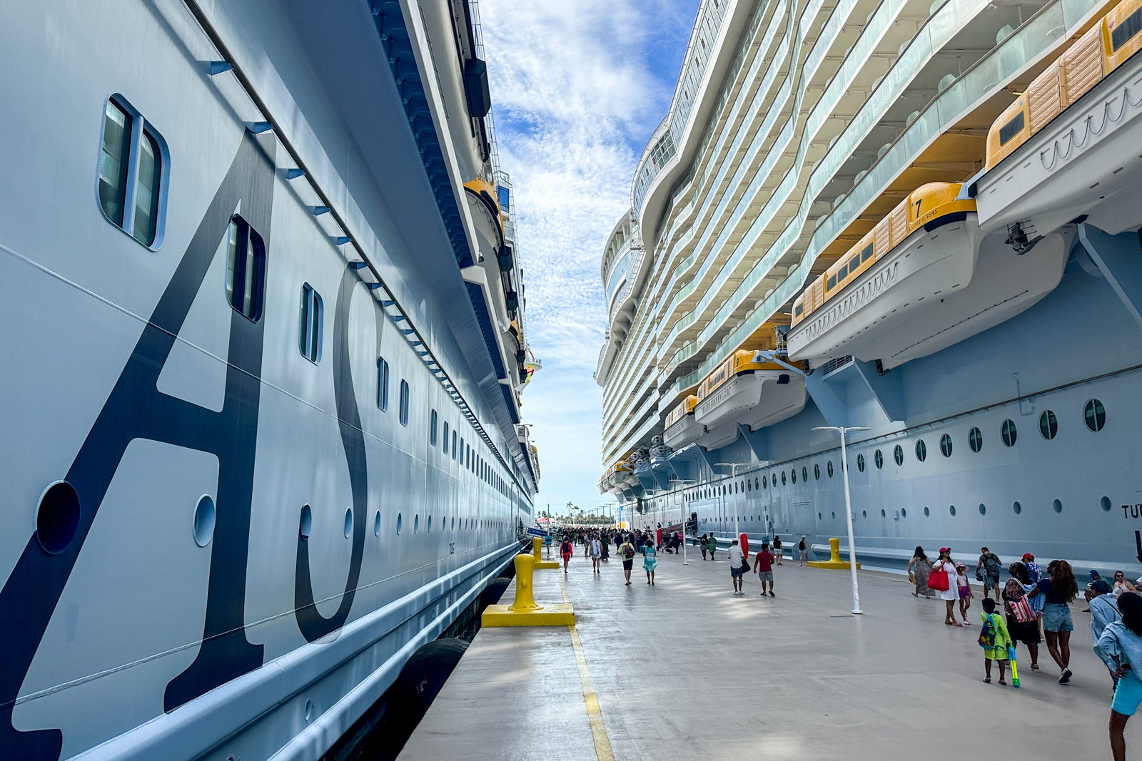 The walkway between two large cruise ships docked next to one another