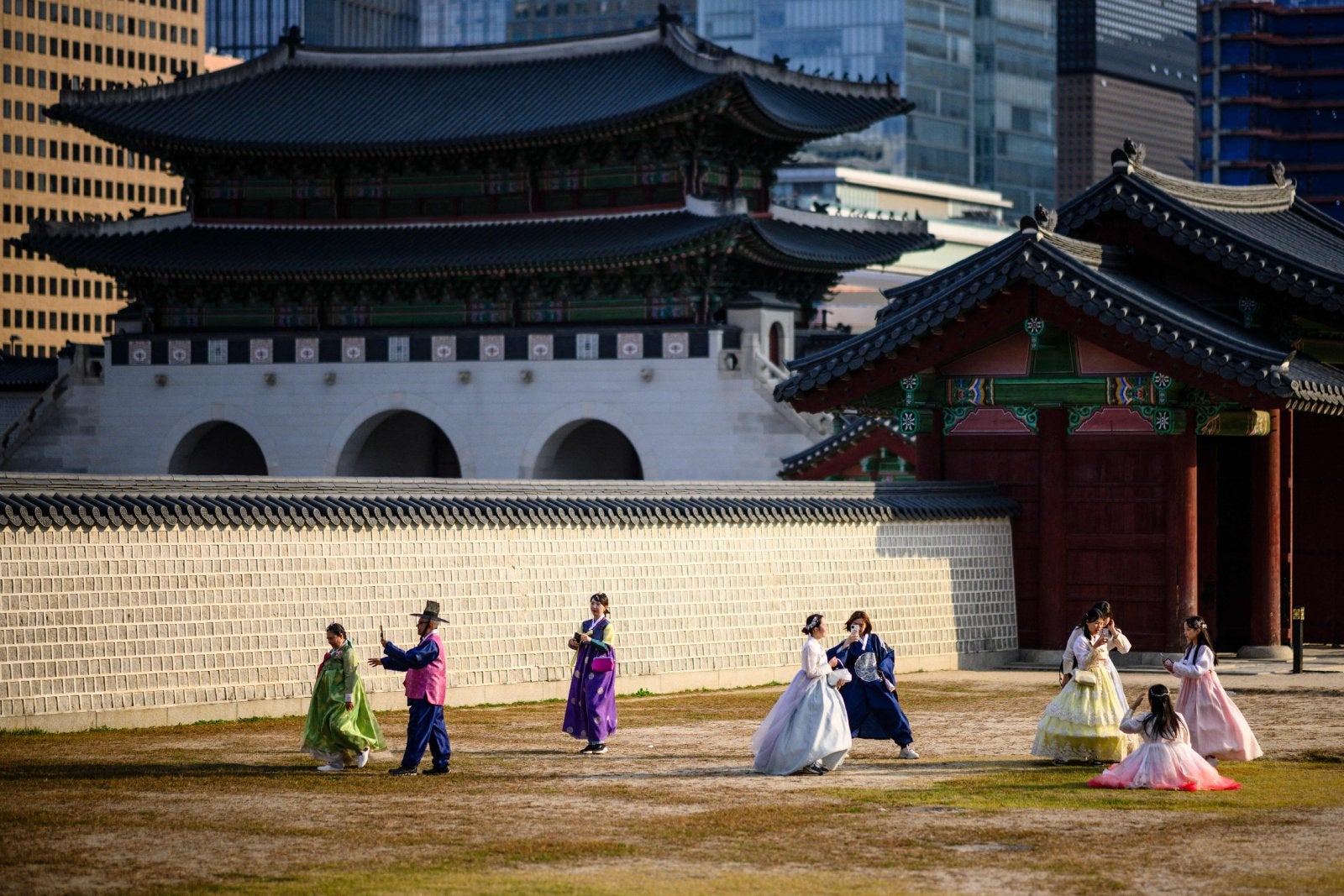 Visitors wearing traditional Hanbok clothes pose for photos at the Gyeongbokgung Palace grounds in Seoul