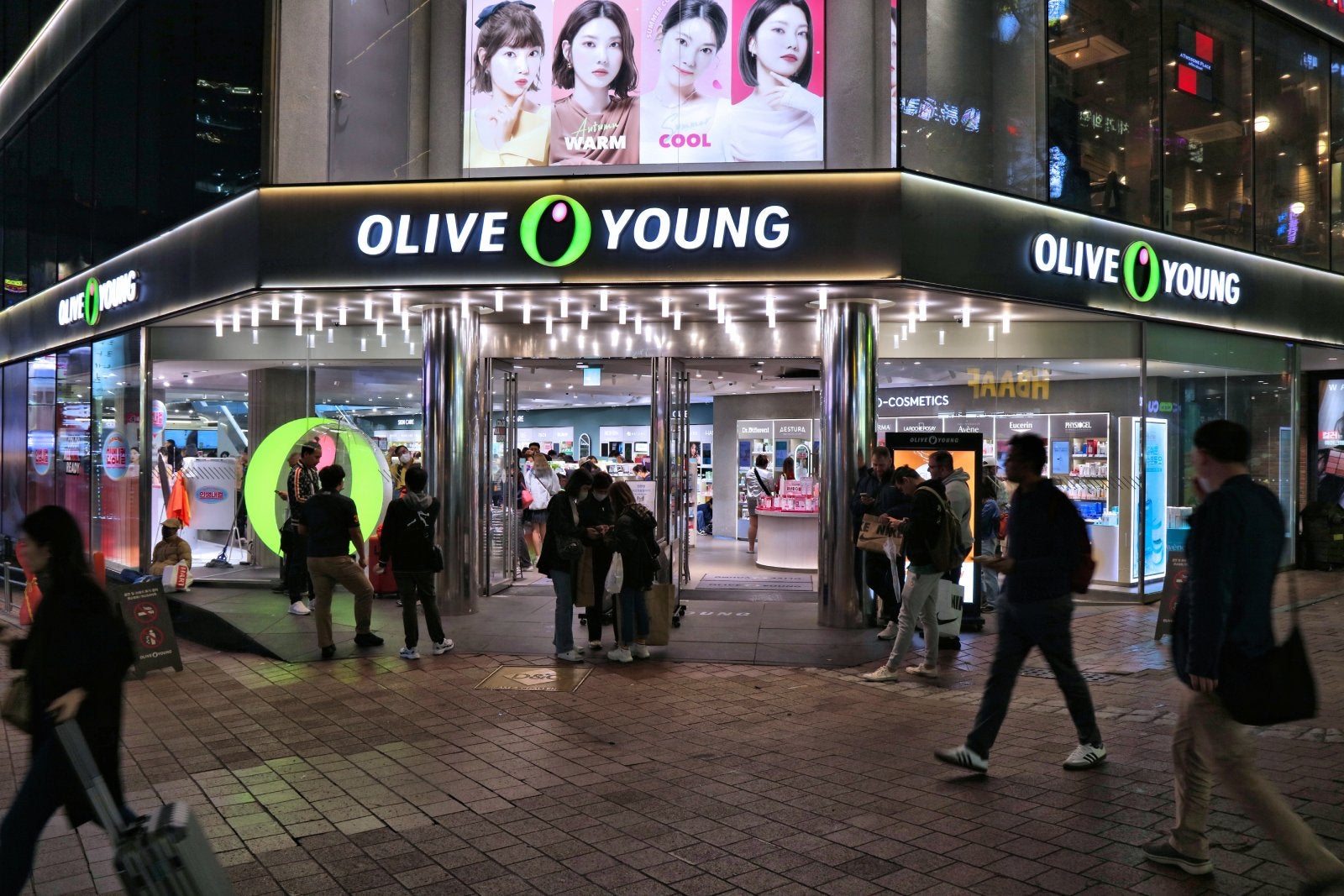 People visit Olive Young Korean beauty store in Myeongdong shopping district in Seoul by night.