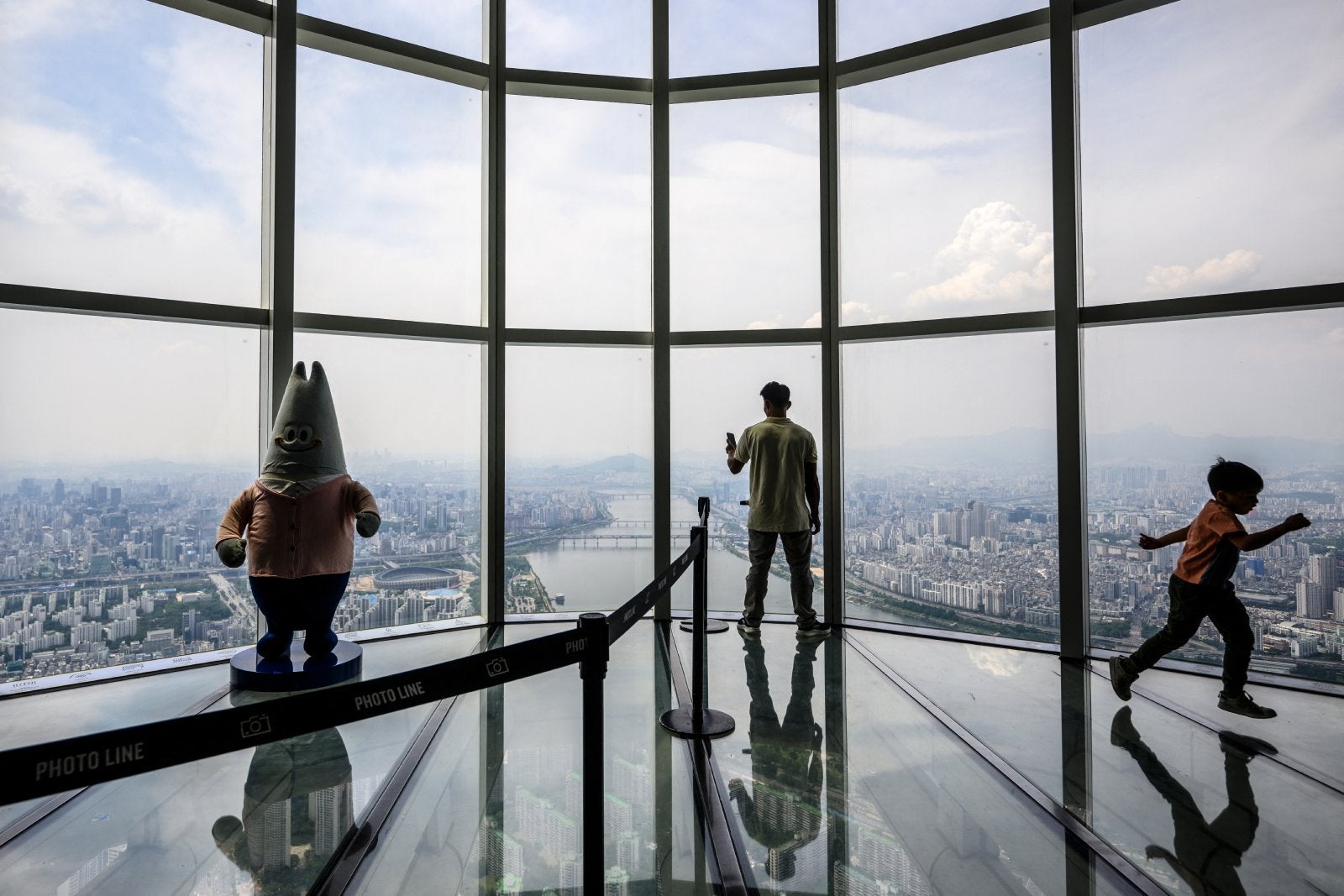 People visit the glass-floored Seoul Sky Observatory in the Lotte World Tower, South Korea's tallest building, in Seoul.