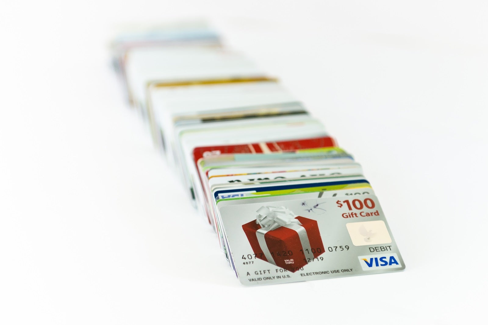 A stack of gift cards with a Visa gift card at the front with a present printed on it