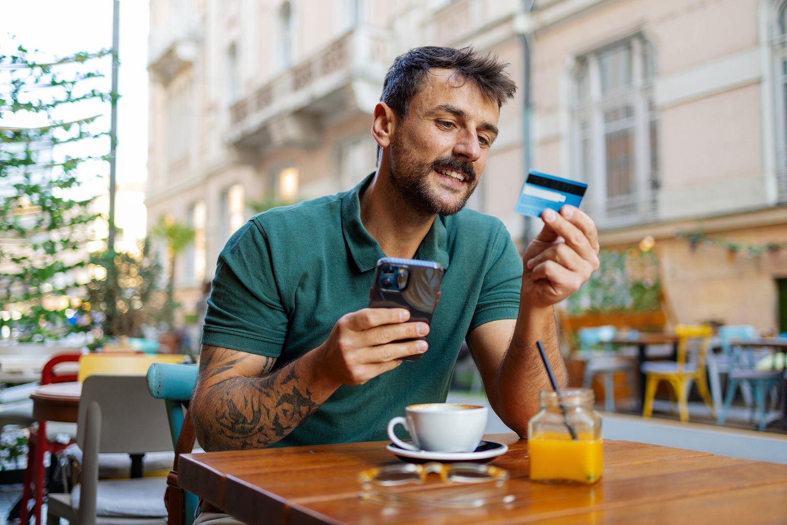 Digital Shopping: Man Using Phone and Credit Card to Make an Online Purchase