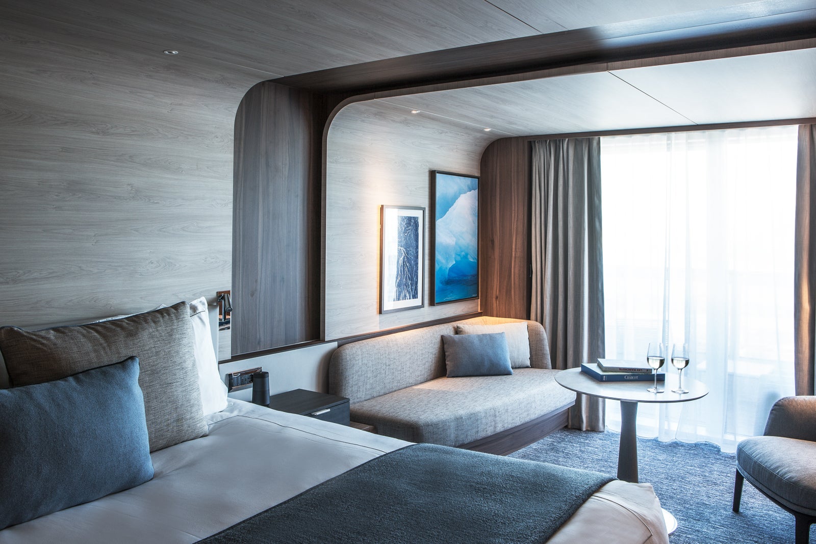 Inside a luxury cabin with a bed, a couch, a small table and a chair.