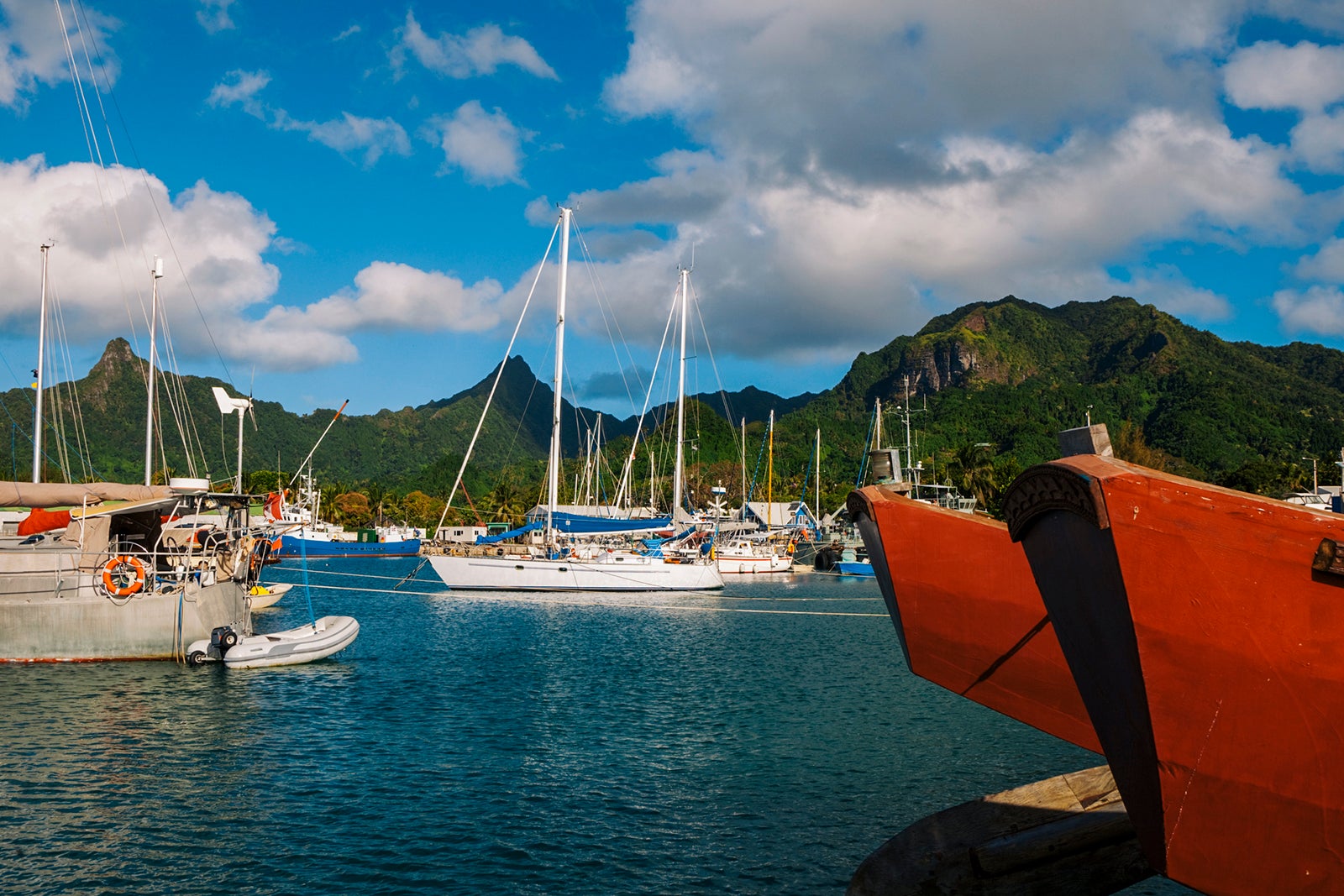 Traditional catamarans and modern yachts docked up in Rarotonga, Cook Islands.