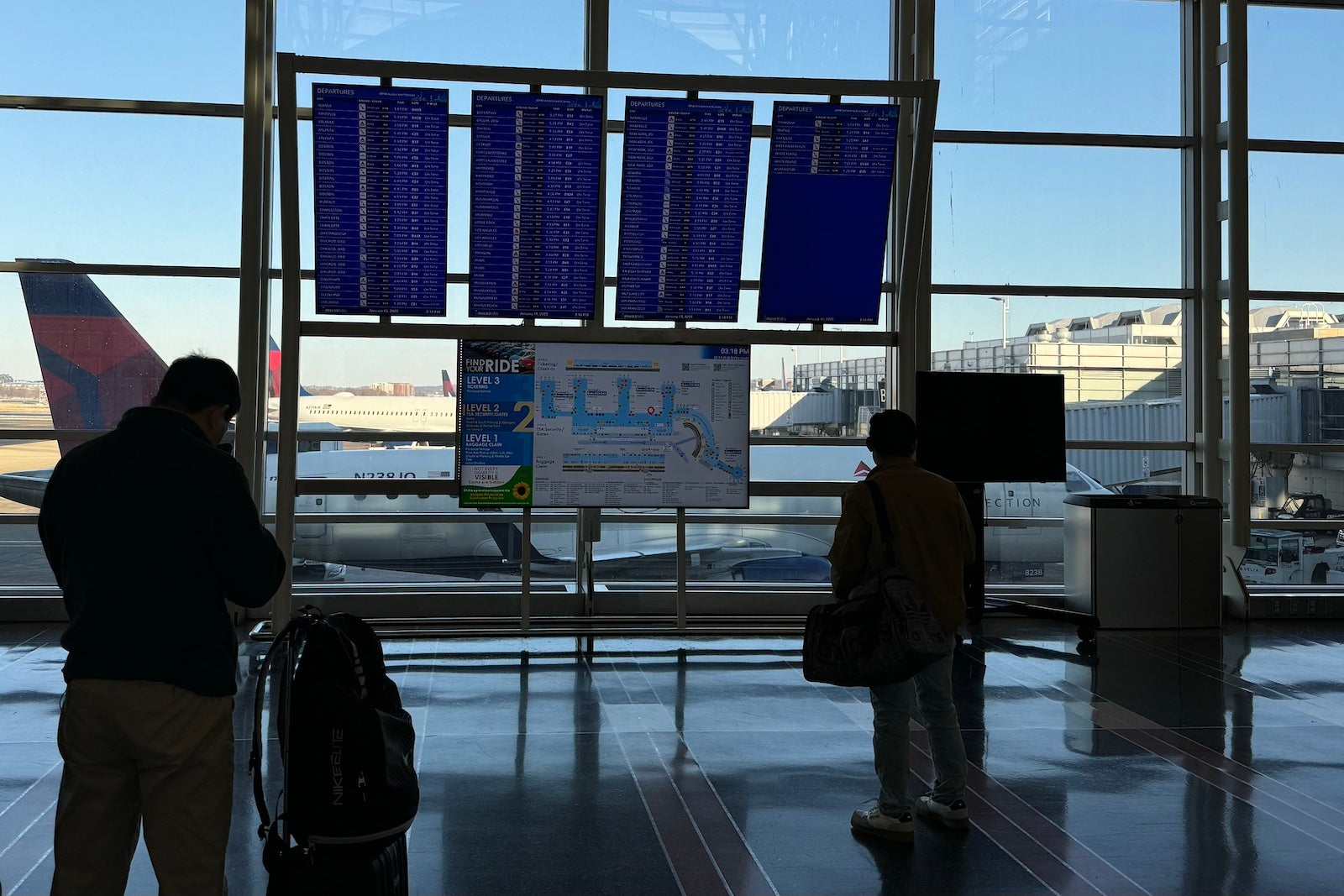 Travelers check their flight status at Ronald Reagan Washington National Airport 