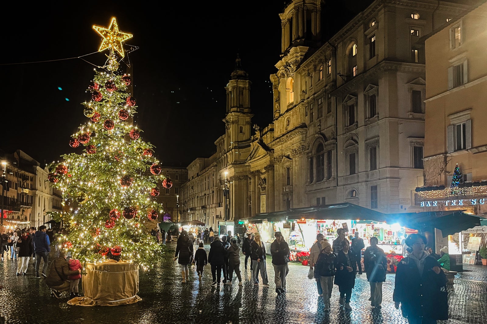 Dark street in Rome with Christmas tree and market stalls