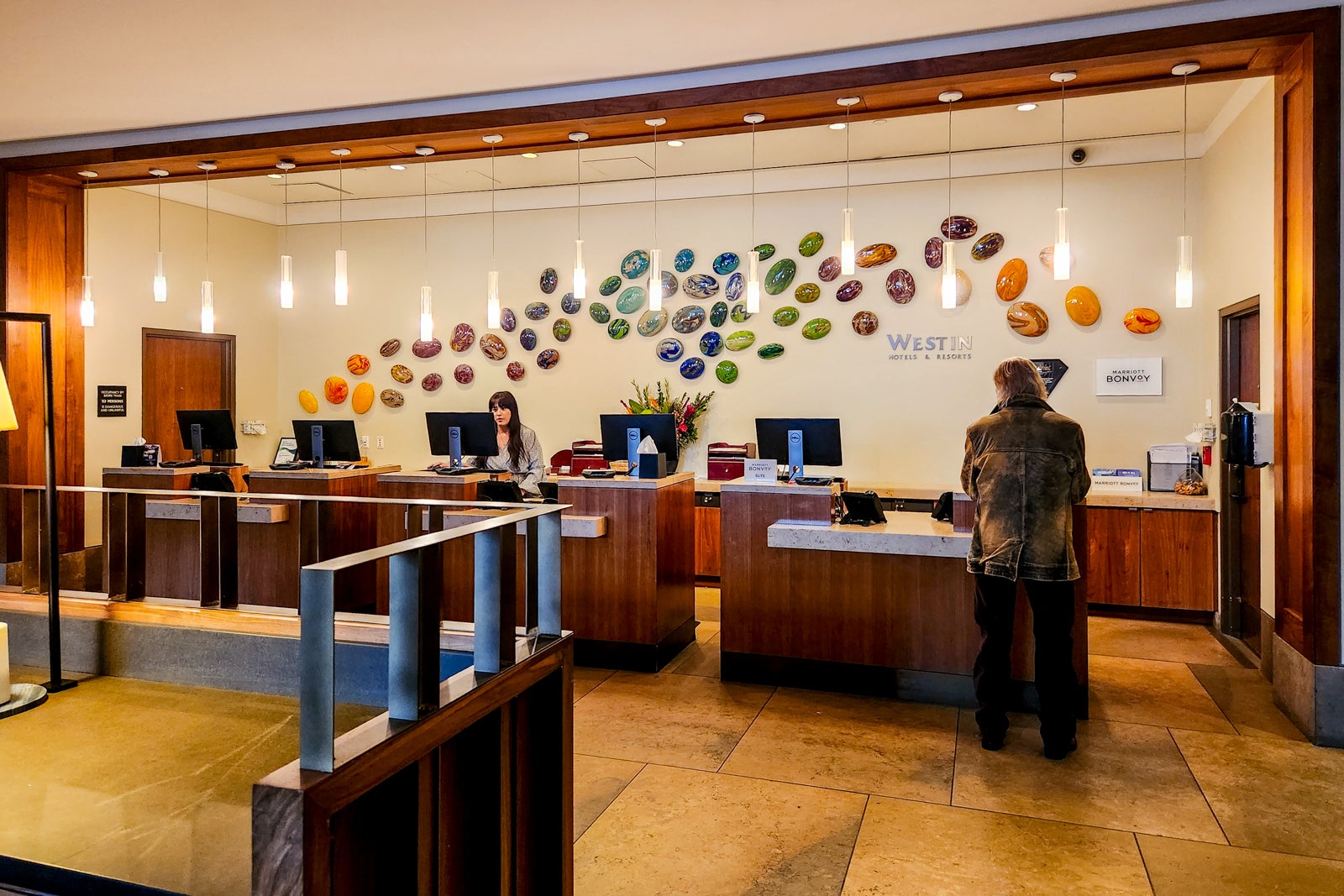 hotel checkin desk with colorful glass stones on wall