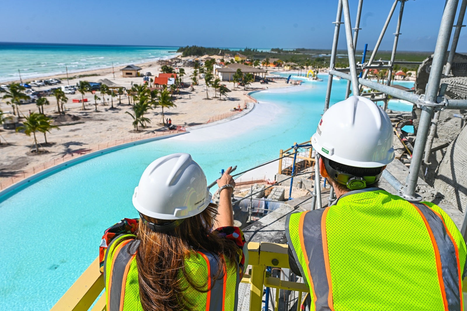 An aerial shot of a lagoon at a cruise line private island with two people looking out over it