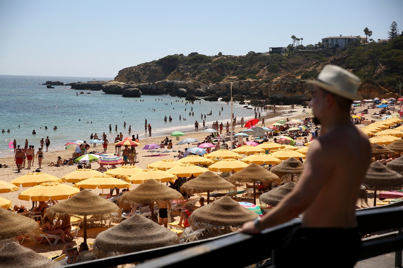 Beachgoers sunbathe and swim at Oura beach in Albufeira, Algarve region, Portugal on August 6, 2022. 