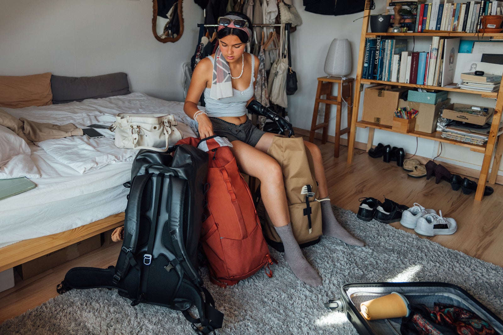 young woman packing backpack and luggage for trip