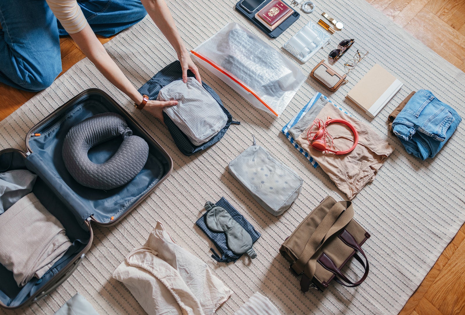 woman packing a cosmetics bag, clothes and accessories in her luggage