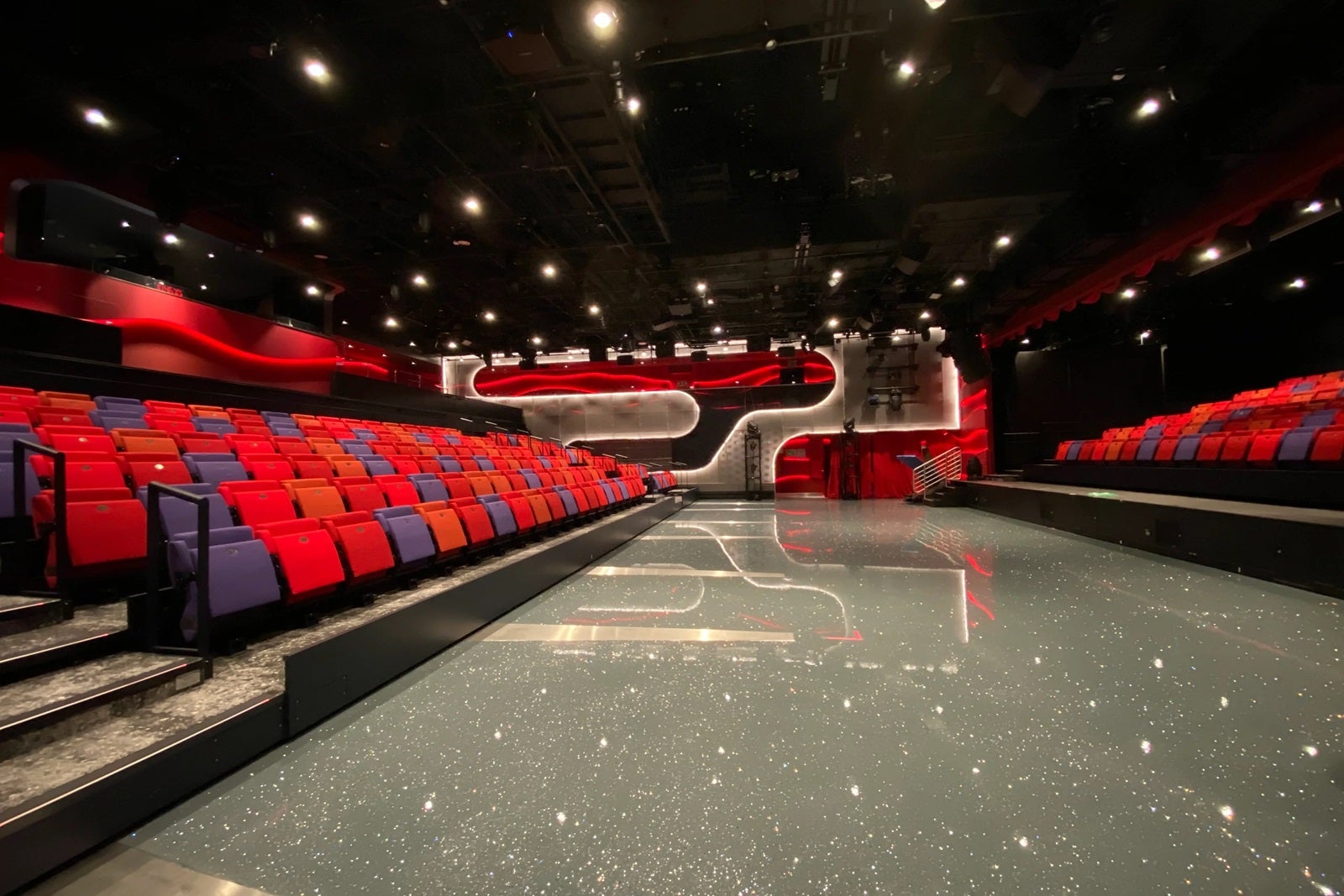 A hard performance floor area with tiered theater seating on each side facing inward