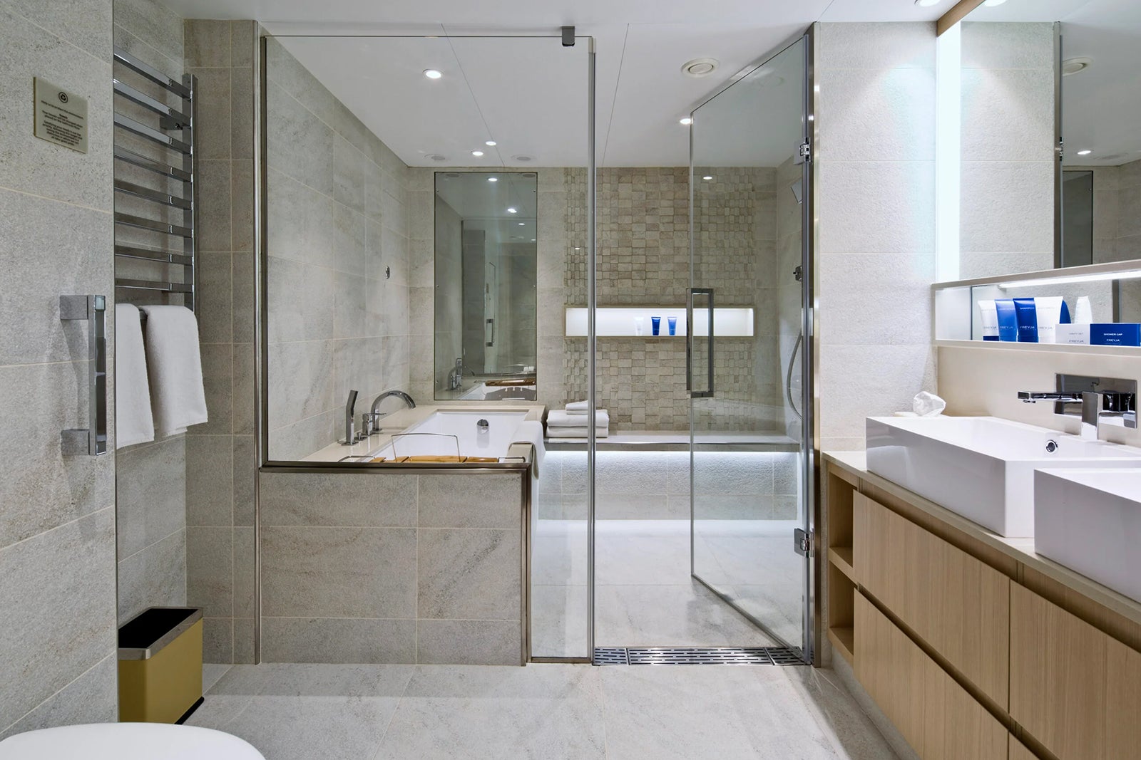 A modern and spacious cruise ship bathroom with glass walled shower