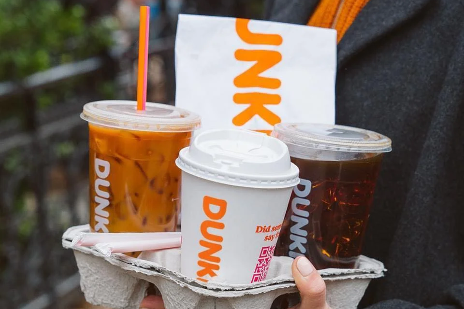 Person holding Dunkin'