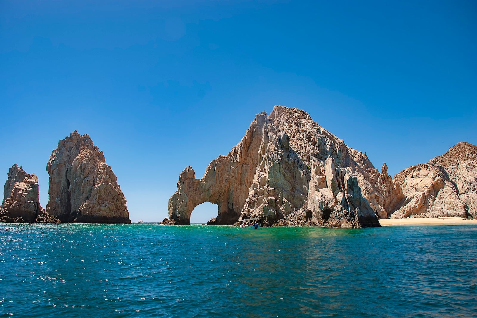 rock arch formation coming out of the blue ocean