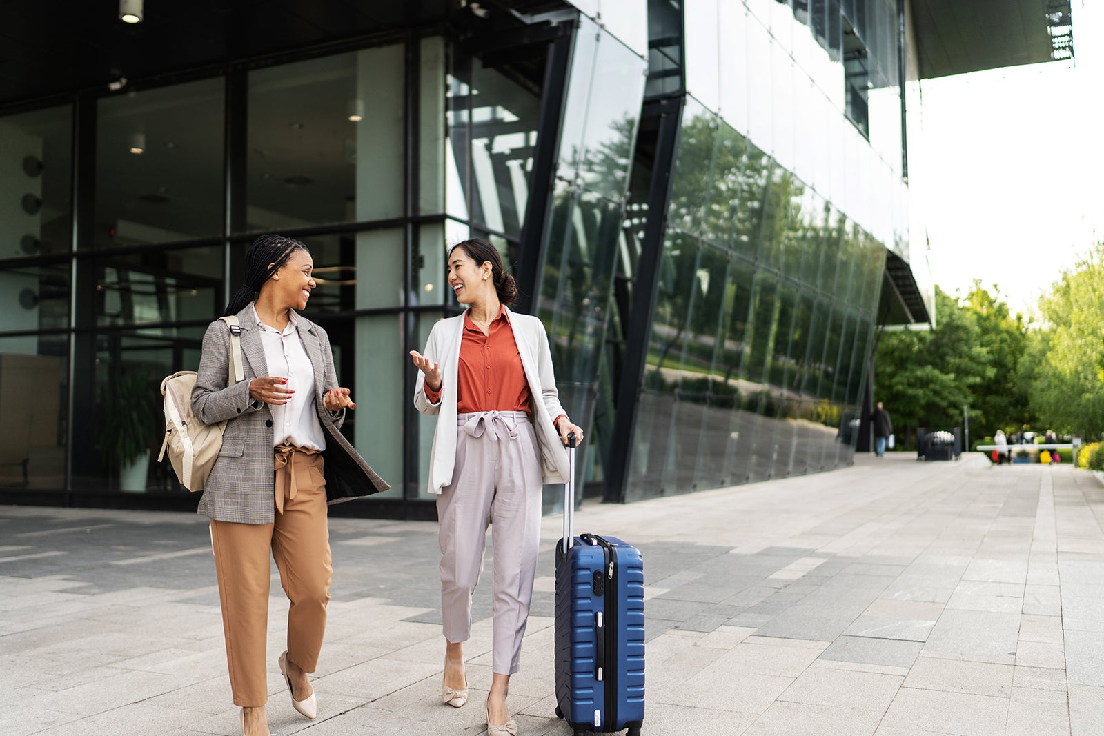 Two businesswomen walking and talking outside office building