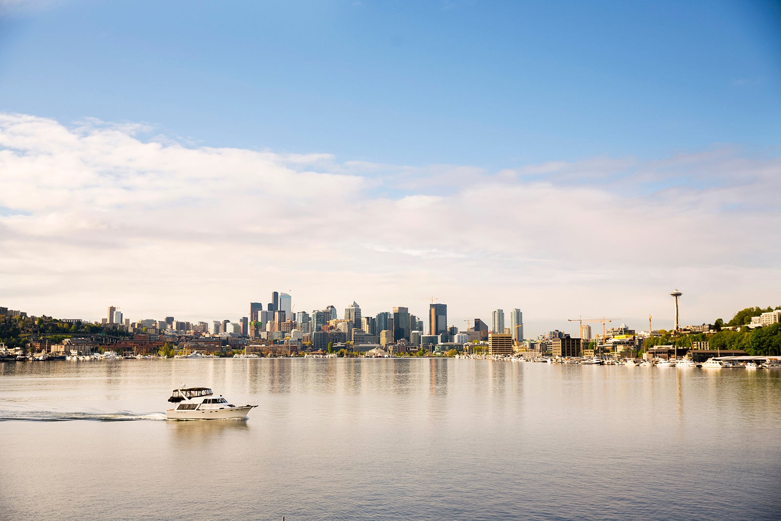 A boat passing by Lake Union with Seattle in the distance.