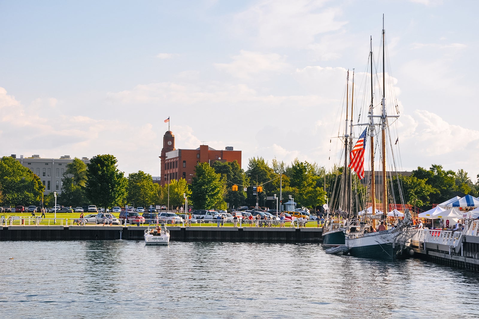 The skyline of Traverse City, Michigan as seen from the waters of Grand Traverse West Bay. Several tall ships and boats are docked in the harbor.